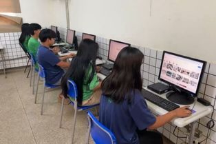 Alunos de uniforme sentados usando o computador