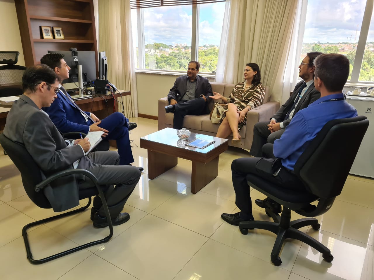 Foto dos advogados e do desembargador César Palumbo sentados em roda na reunião