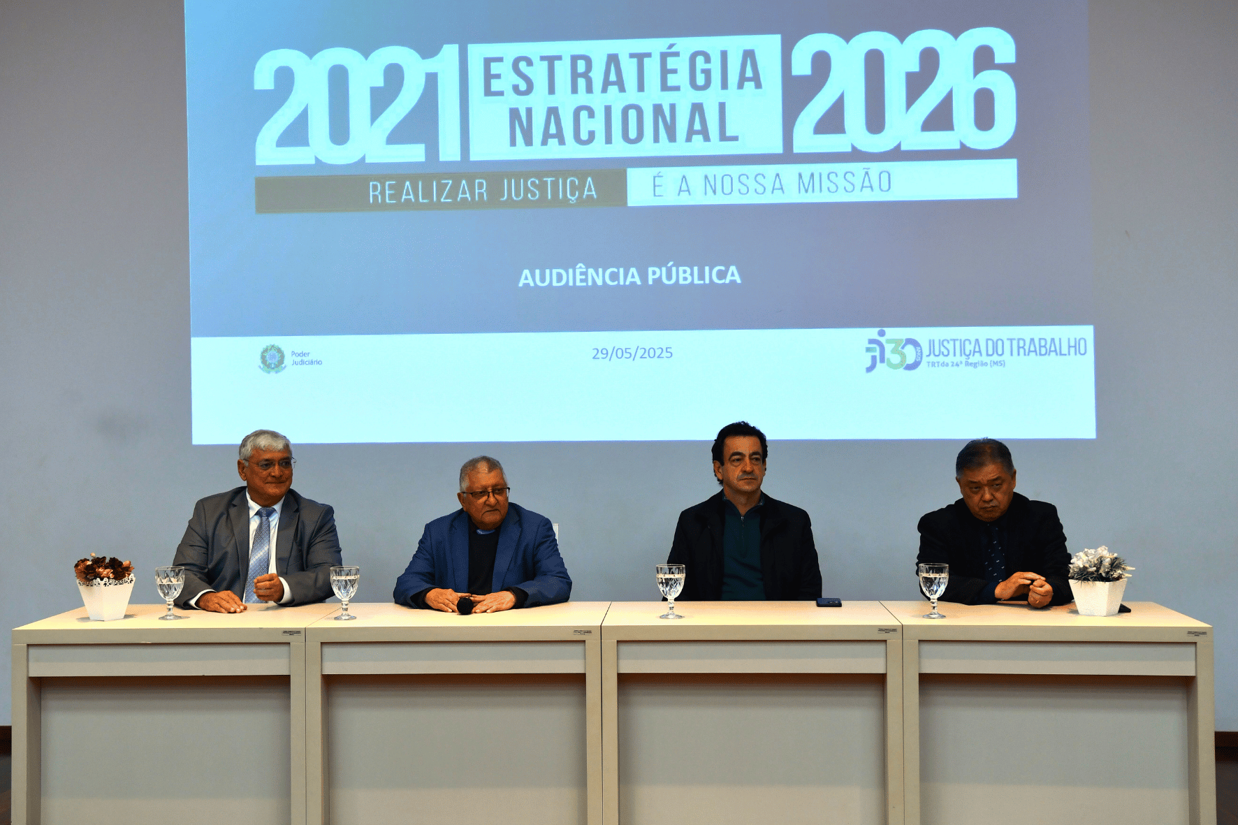 Homens sentados em bancada com projeto ao fundo