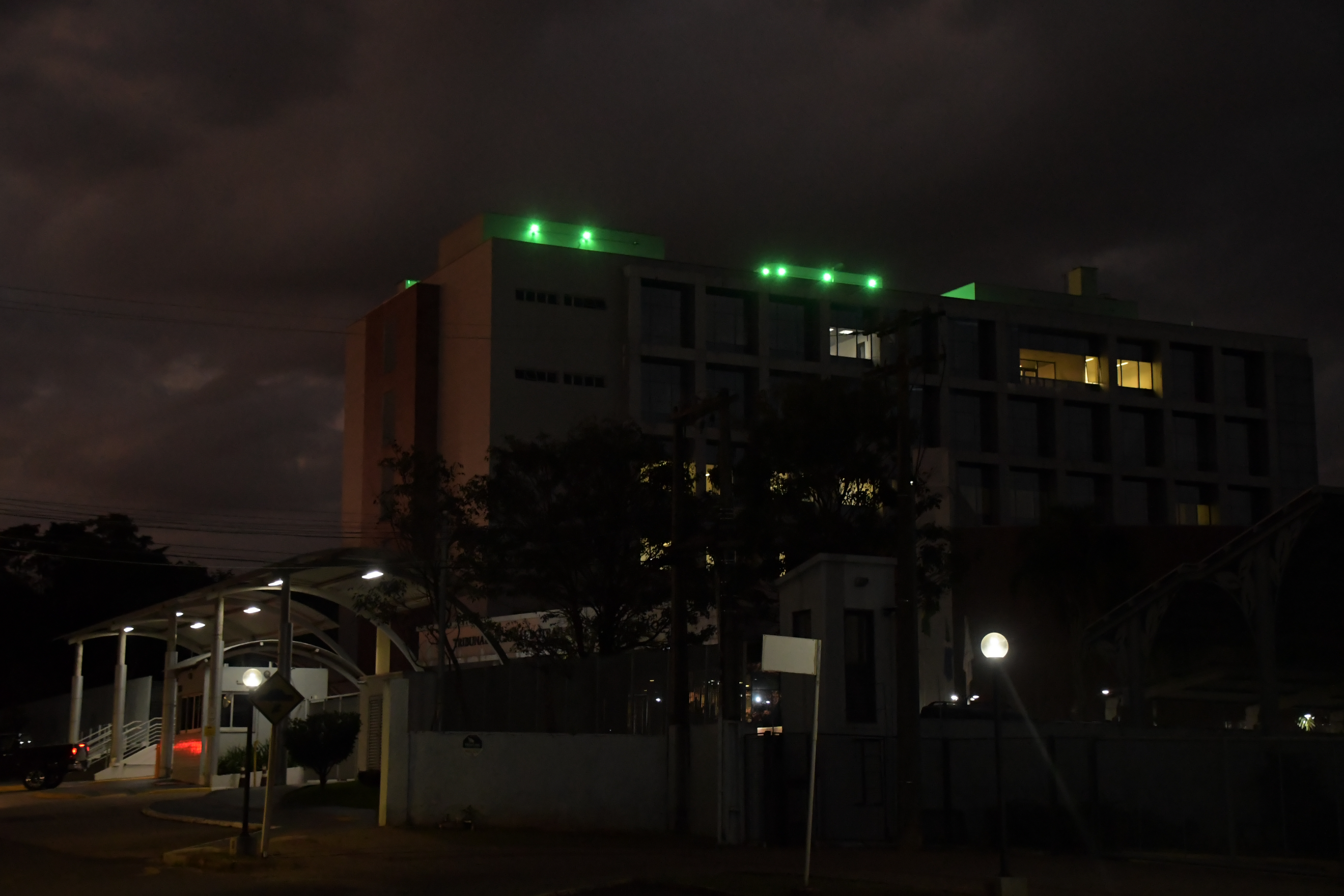 Fachada do tribunal iluminada na cor verde