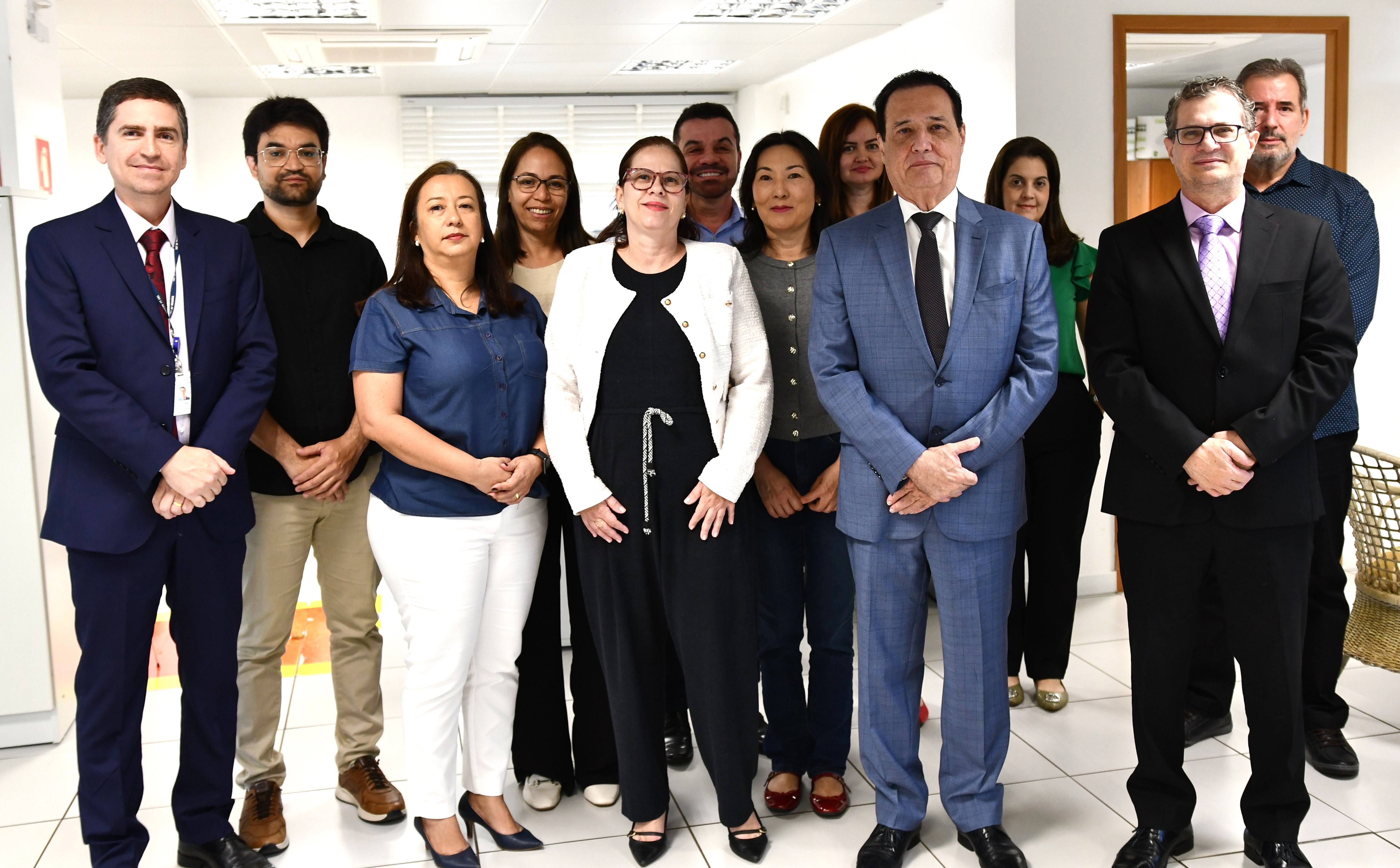 Foto de servidores e servidoras ao lado do presidente do tribunal e do juiz 