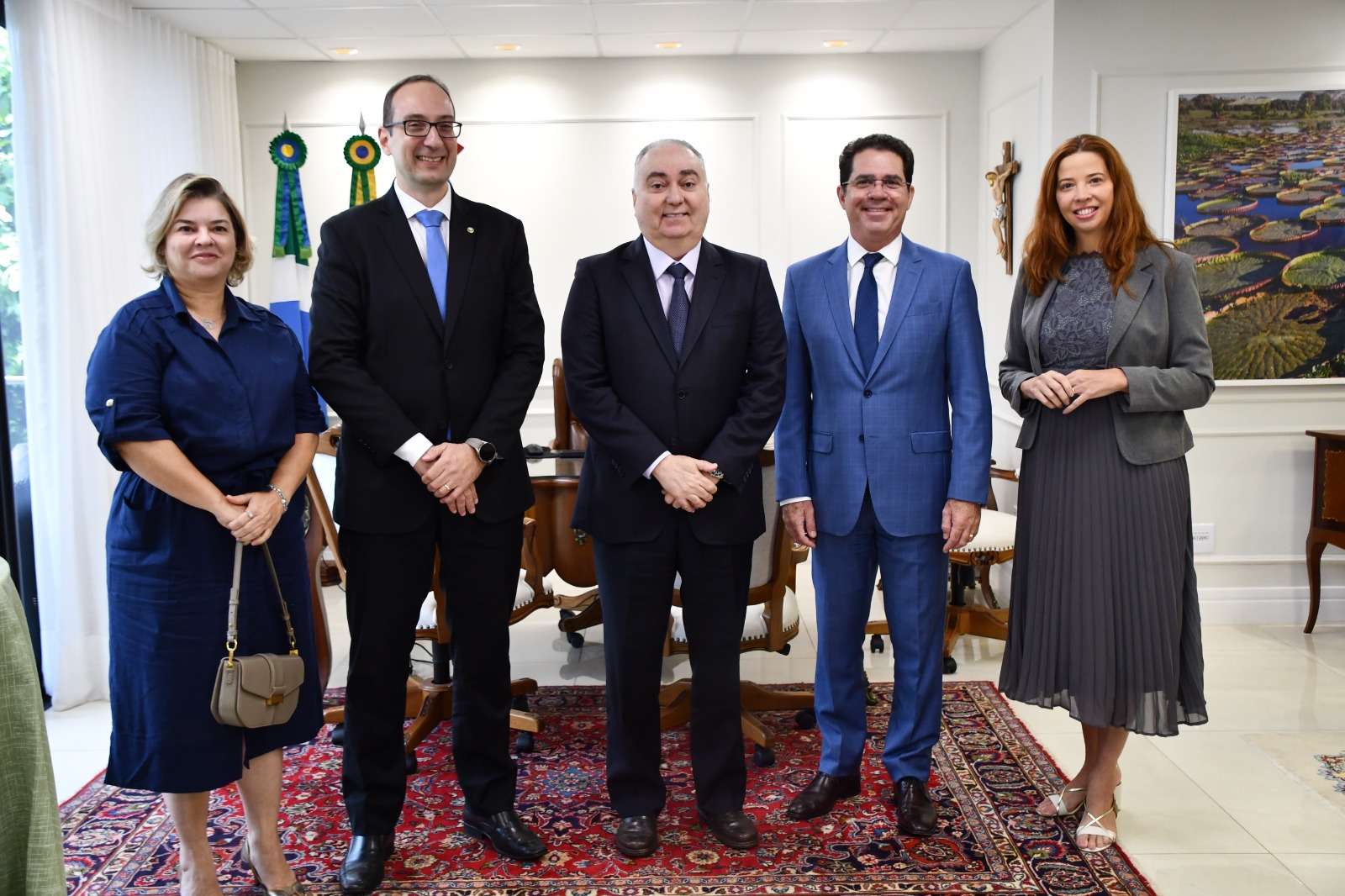 Pessoas em pé, ao fundo bandeiras. 