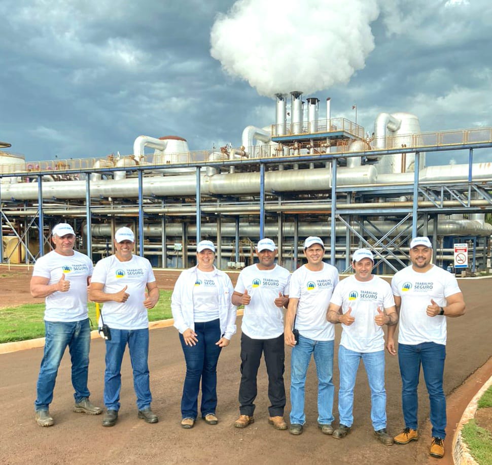 Foto de trabalhadores na frente da usina