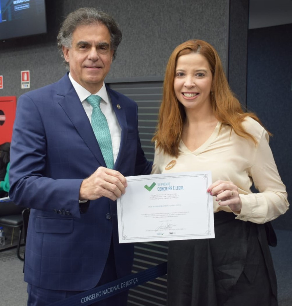 Foto em que a  juíza Déa Yule recebe o seu certificado