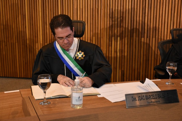 Desembargador João Marcelo realizando uma assinatura.