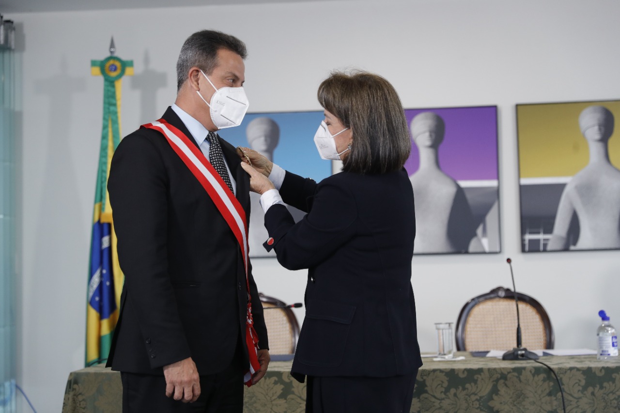 Foto da Ministra Maria Cristina Peduzzi colocando a faixa no Ministro Amaury Rodrigues Pinto Junior empossando-o do cargo