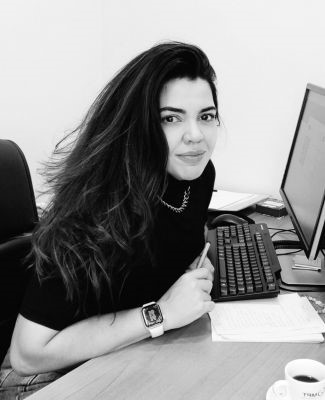 foto em preto e branco da servidora Vanessa Ricarte sentada em frente a um computador